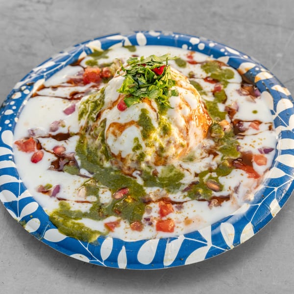 A Bombay street food dish, Raj Kachori, topped with yogurt, chutneys, cilantro, and pomegranate seeds.