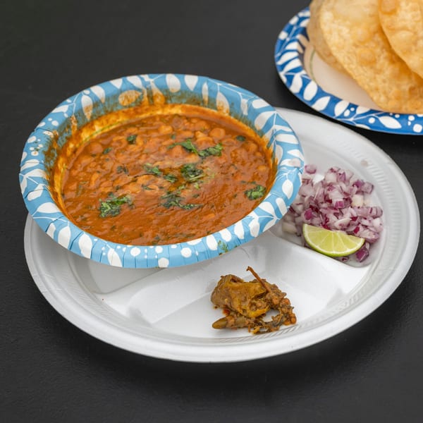 Chaat Ka Chaskaaa's chole bhature with a side of chopped red onions, lime, and a spicy pickle.